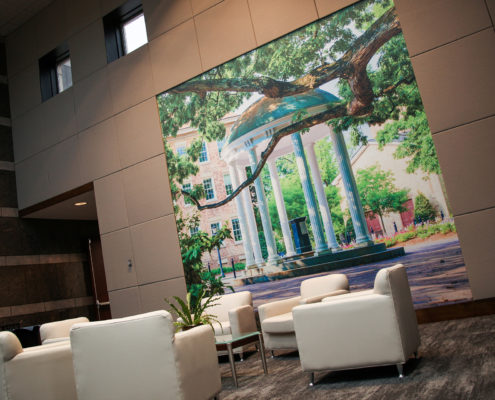A seating area features a picture of the Old Well at UNC-Chapel Hill