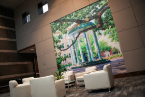 A seating area features a picture of the Old Well at UNC-Chapel Hill